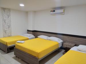 Postel nebo postele na pokoji v ubytování Hotel Ibague Plaza