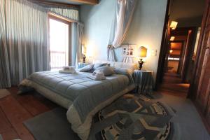 a bedroom with a bed and a large window at Hostdomus - Imperial Chalet in Sestriere
