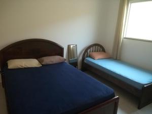 a bedroom with two beds and a window at Casa de praia litoral norte SP in Caraguatatuba