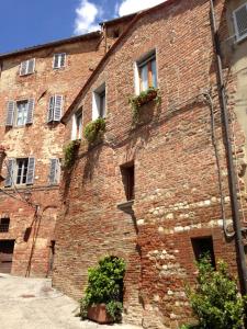 un edificio de ladrillo con ventanas y plantas. en Casina Mazzuoli, en Città della Pieve