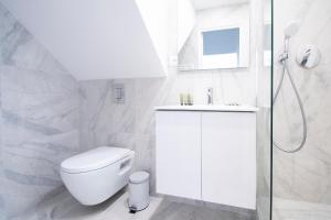 a white bathroom with a toilet and a sink at Dreamyflat - Abbesses in Paris