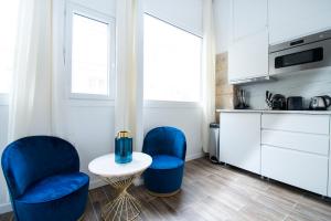 a kitchen with two blue chairs and a table at Dreamyflat - Abbesses in Paris