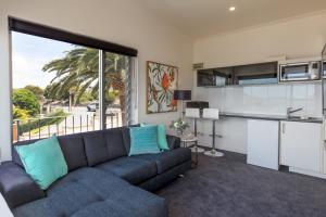a living room with a couch and a kitchen at Bay 10 - Suites and Apartments in Port Lincoln