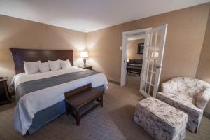 une chambre d'hôtel avec un lit et une chaise dans l'établissement Deer Lake Motel, à Deer Lake