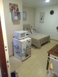 Zimmer mit einer Mikrowelle auf dem Kühlschrank in der Unterkunft MONOAMBIENTE VINTAGE in Mar del Plata