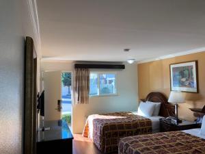a hotel room with two beds and a window at Valley Hotel in Rosemead