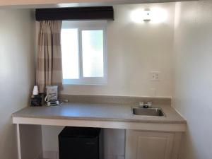 a kitchen counter with a sink and a window at Valley Hotel in Rosemead