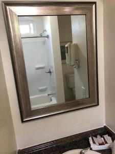 a mirror in a bathroom with a sink and a toilet at Valley Hotel in Rosemead