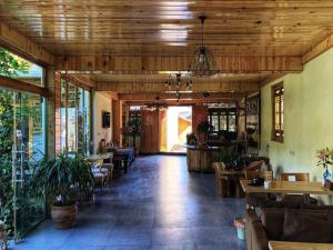 a restaurant with wooden ceilings and tables and chairs at Tourist Courtyard Hotel in Jianchuan