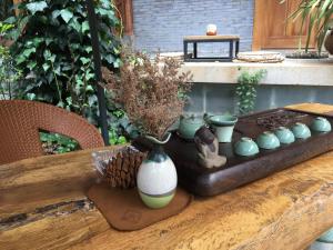 a wooden table with a bunch of vases on it at Tourist Courtyard Hotel in Jianchuan