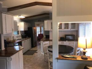 a kitchen with white cabinets and a table and a refrigerator at Beaufort SC New Renovation, Close to Parris Island, Historic Downtown, Beautiful Beaches, Sleeps 6 in Beaufort
