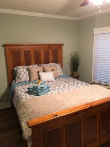 a bed with a wooden headboard in a bedroom at Beaufort SC New Renovation, Close to Parris Island, Historic Downtown, Beautiful Beaches, Sleeps 6 in Beaufort