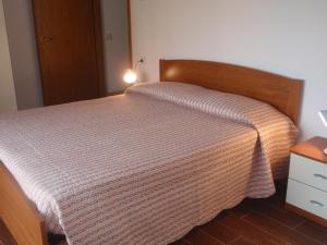 a bedroom with a bed with a wooden headboard at Casa Candida in Gravedona