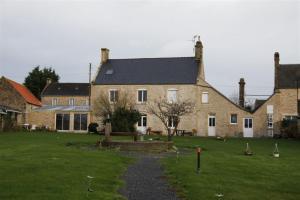 una gran casa de ladrillo con un patio de hierba en Maryse et Jean-Pierre, en Longues-sur-Mer
