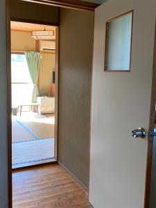 a door leading into a room with a bedroom at Minshuku Nodoka in Yakushima