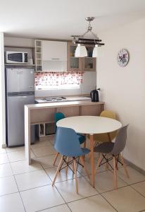 cocina con mesa y 4 sillas en Condominio Costanera del Mar, en La Serena