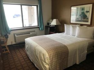 Sun PrairieにあるValued Stay Sun Prairieの大きなベッドと窓が備わるホテルルームです。