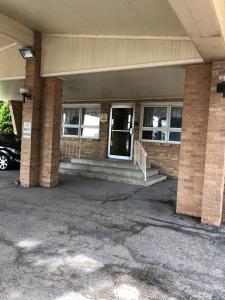 un edificio de ladrillo con una puerta y escaleras en un aparcamiento en Valued Stay Sun Prairie, en Sun Prairie