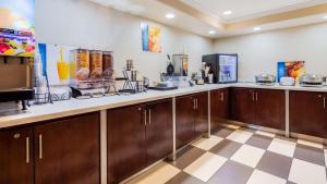 a kitchen with wooden cabinets and a checkered floor at Best Western Skyline Motor Lodge in Lakeview