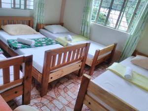 Pokój z 4 łóżkami i krzesłami oraz oknem w obiekcie Savta Homestay w mieście Banaue