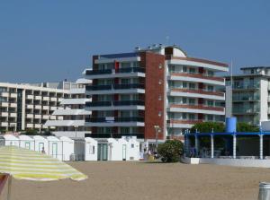 un edificio sulla spiaggia con ombrellone in spiaggia di Residence Panorama Apart Hotel a Bibione