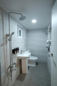 a bathroom with a sink and a shower and a toilet at Daol Guesthouse in Seoul