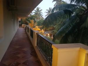 a balcony of a house with a fence and palm trees at Areia De Goa, Comfort Stay Apartment near Baga Beach in Baga +6 photos