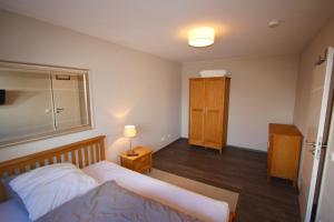 a bedroom with a bed and a cabinet and a lamp at Appartement Moulineaux in Hemmingen