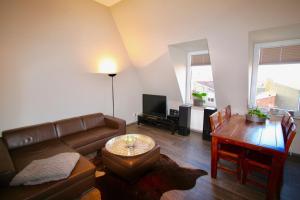 uma sala de estar com um sofá e uma mesa em Appartement Moulineaux em Hemmingen