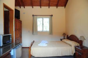 a small bedroom with a bed and a window at Corazon de Montaña in Merlo