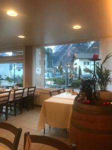 un restaurant avec des tables et des chaises et une grande fenêtre dans l'établissement Hotel Hahnenblick, à Engelberg