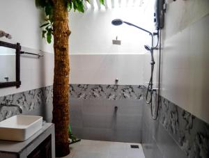 une salle de bain avec une douche et un arbre dedans dans l'établissement Rovenluck Eco Cabana, à Weligama 70 autres photos