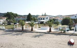 a group of palm trees on a sandy beach at UMBRELLA BEACH APARTMENTs in Kavos