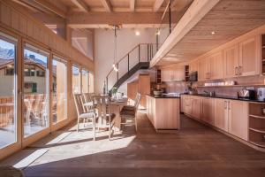 a kitchen with wooden cabinets and a table and chairs at Chalet Aquila 8 Penthouse in Wengen