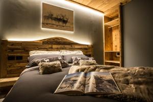 a bedroom with a bed with two books on it at Alpine Rooms Guesthouse in Breuil-Cervinia
