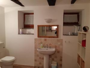 W łazience znajduje się umywalka, toaleta i lustro. w obiekcie Lilla w mieście Premeno