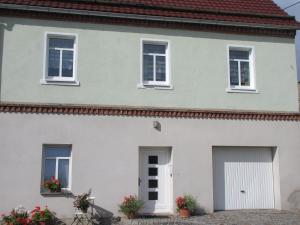 ein weißes Haus mit zwei Garagentüren in der Unterkunft Ferienhaus am Hutberg in Großschönau