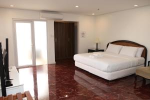 a bedroom with a white bed and a television at Centtro Residences in Los Baños