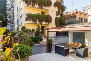 un patio al aire libre con muebles y plantas en un edificio en Patrizia Romana Palace, en Roma