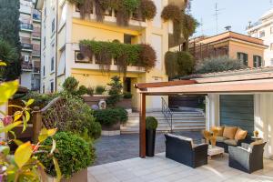 un patio esterno con mobili e piante in un edificio di Patrizia Romana Palace a Roma