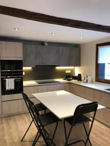 a kitchen with a white table and two chairs at Très spacieux chalet rénové été 2026 - 14 personnes coeur de village 150 m des pistes - in Montgenèvre +10 photos