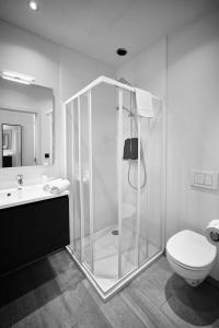 a bathroom with a glass shower and a toilet at Hotel Le Parisien in Ostend