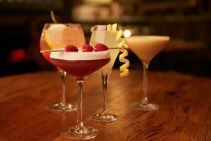 three wine glasses with desserts in them on a table at The Plough Inn & Cottages in Scarborough