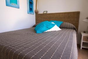 - une chambre avec un lit doté d'un oreiller bleu dans l'établissement Gamberino, à Île de Capraia