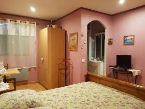 Flassans-sur-IssoleにあるCasa das Oliveirasのピンクの壁のベッドルーム(ベッド1台、テレビ付)