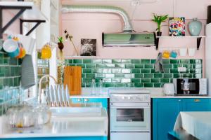 a kitchen with blue cabinets and green tiles at Eden Hotel Bangsean in Ban Laem Thaen