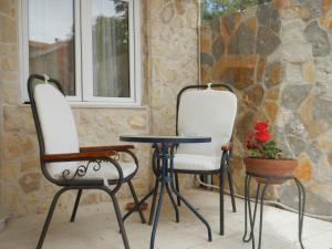 two chairs and a table in front of a stone wall at Apartments Ankica in Šibenik