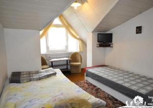 a bedroom with two beds and a tv on the wall at Aura in Szklarska Poręba