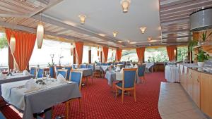 un restaurante con mesas blancas y sillas azules en Hotel Restaurant Jaegersteig en Bühl