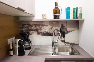 a sink in a kitchen with a picture of a person skiing at Am Wasserfall 31 in Bad Gastein